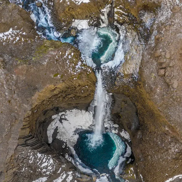 Litlanesfoss şelalesinin hava manzarası Doğu İzlanda 'daki buzlu bazalt kayalıklarından dökülüyor.