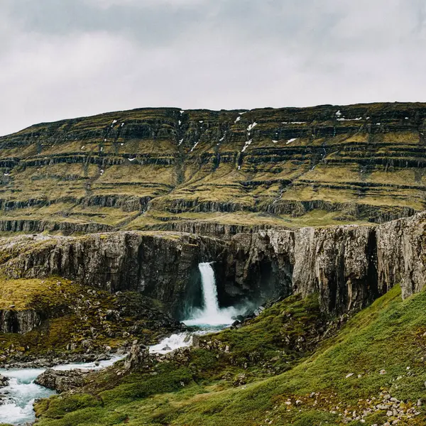 Folaldafoss şelalesinin Doğu İzlanda 'daki engebeli uçurumlardan dökülüşünün manzarası.