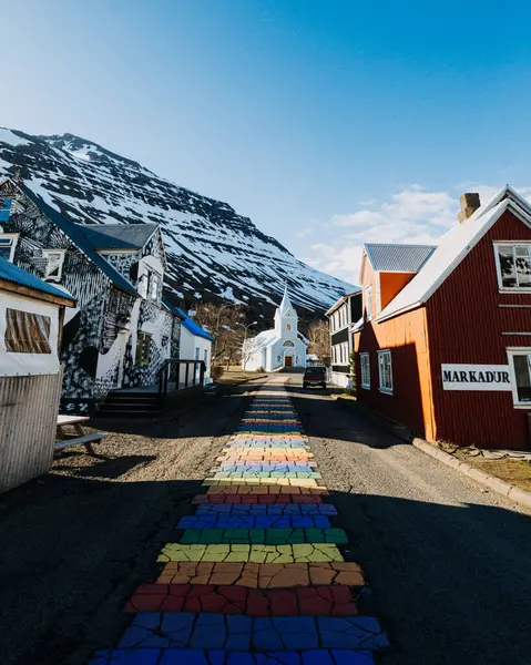 Renkli gökkuşağı caddesi Seydisfjordur, Doğu İzlanda 'da ikonik mavi kiliseye çıkıyor.