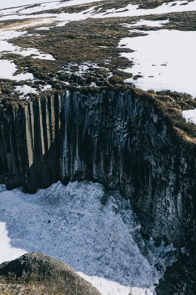 Doğu İzlanda 'daki Studlagil Kanyonu' nda kışın karla kaplı bazalt kayalıklar