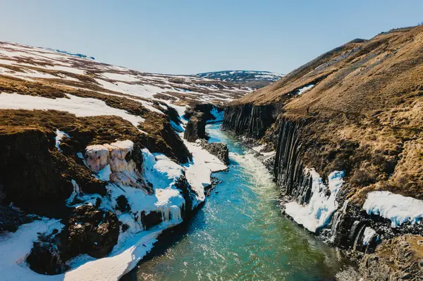Erken bahar manzaralı Studlagil Kanyonu eriyen karlar ve bazalt duvarlarla