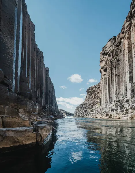 Doğu İzlanda 'daki Studlagil Kanyonu' ndaki buzul nehrinin üzerinden yükselen bazalt kayalıkları