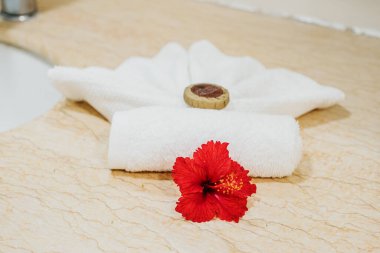 Moorea, Fransız Polinezyası 'nda kırmızı amber çiçeğiyle spa havlusu düzenleme.