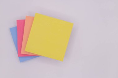Yellow Pink Peach Blue post it note stacked isolated on white background. Four Stacks of post it notes including Yellow Pink Peach Blue stacked isolated on white background clipart