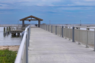Balıkçı iskelesi, Fort DeSoto Park St. Petersburg Tampa Florida USA 'daki açık bulutlu mavi gökyüzüne kadar uzanıyor.
