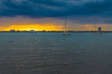 This beautiful sunset photograph captures the tranquil beauty of Bayfront Park in downtown Sarasota, Florida. The warm, golden light of the setting sun casts a soft glow over the calm waters of Sarasota Bay clipart