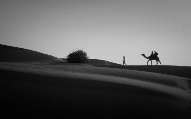 Yaz boyunca seyahat. Turist, Sam 'in kum tepeleri çölünün, Jaisalmer' in, Rajasthan 'ın, Hindistan' ın ortasında devenin üstünde gezintiye çıkıyor..