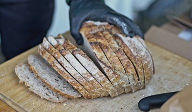 Eldivendeki bir el ekmeği alır.