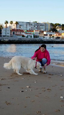 Portekiz 'de okyanus kıyısında köpeğini eğiten bir kız. Yumuşak odak