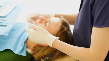 İmplantların rengini doktor seçer. Hasta Avrupalı görünümlü genç bir kadın. Yumuşak odaklanma. Yakın plan