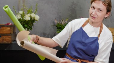 Çiçekçi iş için ambalaj kağıdı seçiyor. Küçük bir iş. Yakın plan.