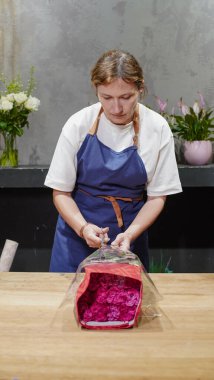 Çiçekçi bir paket gül açıyor. Küçük bir iş. Yakın plan. Yumuşak odak.