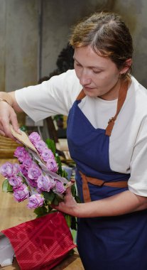 Çiçekçi bir paket gül açıyor. Küçük bir iş. Yakın plan. Yumuşak odak.