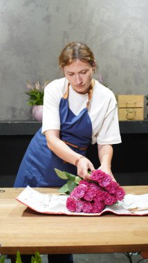 Çiçekçi bir paket gül açıyor. Küçük bir iş. Yakın plan. Yumuşak odak.