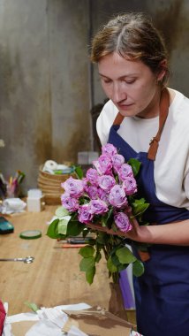Çiçekçi bir paket gül açıyor. Küçük bir iş. Yakın plan. Yumuşak odak.