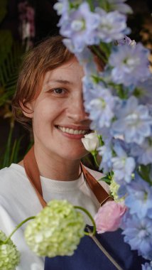 Çiçekçide bir çiçekçi mavi desenlerden bir buket yapar. Küçük bir iş. Yakın plan. Yumuşak odak.