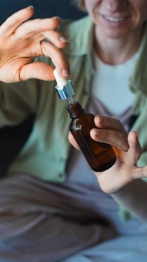 Blogcu, cep telefonunun kamerasına bir şişe kozmetik açıyor ve bir tripoda monte edilip bir LED lambayla aydınlatılıyor. Yakın plan. Yumuşak odak