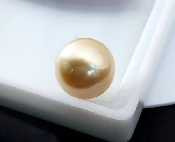 stock image A Single Golden Pearl. Perfect-Round and Smooth, Lustrous Surface on a white box