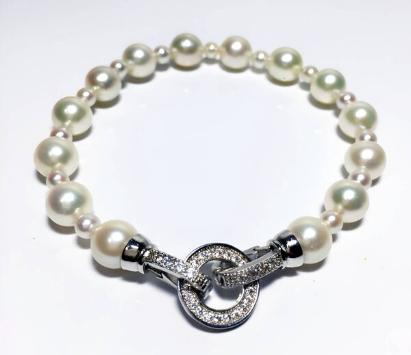 A delicate bracelet featuring creamy white pearls and a sparkling cubic zirconia clasp. Perfect for adding a touch of classic elegance to any outfit.