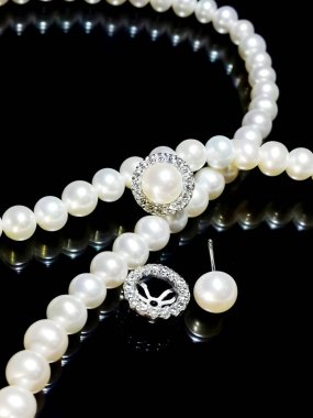 Çarpıcı inci kolye ve küpe seti. Karmaşık detaylar içeriyor. Düğünler, partiler ya da özel durumlar için mükemmel. Zarif ve zamansız.