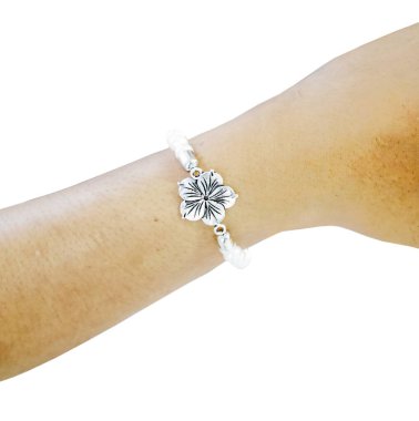 Zarif bir dizaynı olan güzel çiçekli inci bir bilezik, zarif bir kadın bileğinde dinleniyor. Kişisel stili ve aksesuarları geliştirmek için mükemmel.