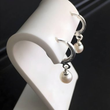 Zarif bir inci kolye içeren zarif gümüş halka küpeler keşfedin. Her durum için mükemmel, bu şık aksesuar biraz incelik katıyor..