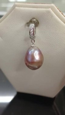 Güzel bir Barok inci kolyesinin yakın plan videosu eşsiz organik şeklini ve ışıltılı parıltısını sergiliyor..