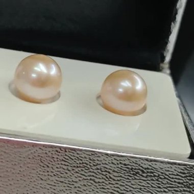 Siyah arkaplanı olan bir mücevher kutusunda zarif yuvarlak altın inciler.