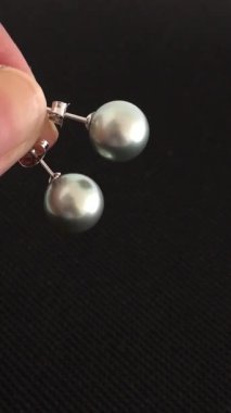 Zarif Gümüş Gri İnci küpeler Parmaklar Arasında Odaklanmış Atış