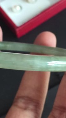 Ahşap bir yüzeyde Parlak Yeşil Yeşim Taşı Tutarken Yakın Çekim