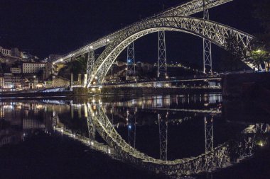 2024 Haziran 01; Porto; Douro Nehri 'nin Sersemletici Yansımaları ile Dom Luis Köprüsü' nün Gece Görüşü, Iconic Mimari Tasarım ve Aydınlatılmış Şehir Düzenlemesi