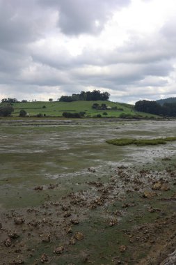 Santoa, Cantabria İspanya 'yı gökyüzünün sularında ve günbatımında bulutlarda kayık ve yansımalarla batırdı.