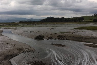 Santoa, Cantabria İspanya 'yı gökyüzünün sularında ve günbatımında bulutlarda kayık ve yansımalarla batırdı.