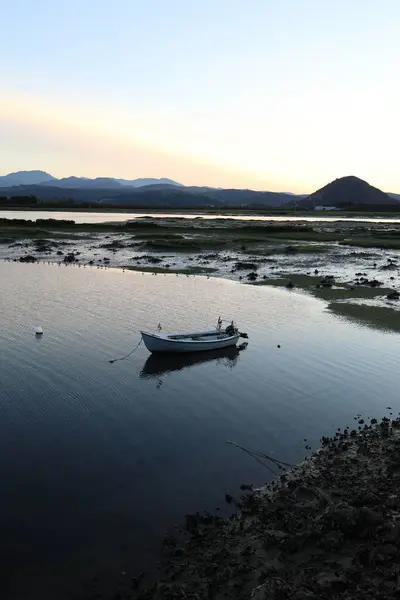 Santoa, Cantabria İspanya 'yı gökyüzünün sularında ve günbatımında bulutlarda kayık ve yansımalarla batırdı.