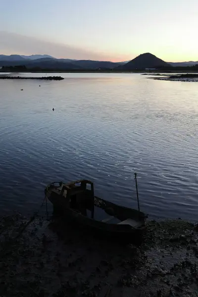 Santoa, Cantabria İspanya 'yı gökyüzünün sularında ve günbatımında bulutlarda kayık ve yansımalarla batırdı.