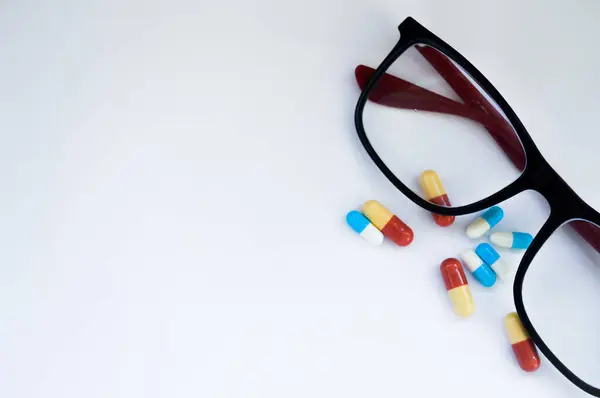 Beyaz arka planda gözlük ve ilaç hapları. Antidepresan ve akıl sağlığı konsepti. Yüksek kalite fotoğraf