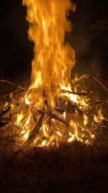 Geceleri yanan büyük bir şenlik ateşi, dışarıyı aydınlatan alevler ve kıvılcımlar. Yüksek kalite 4k görüntü