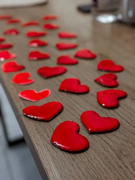 Ahşap yüzeyde kırmızı kalp şeklinde dekorasyonlar. Yüksek kalite 3d illüstrasyon