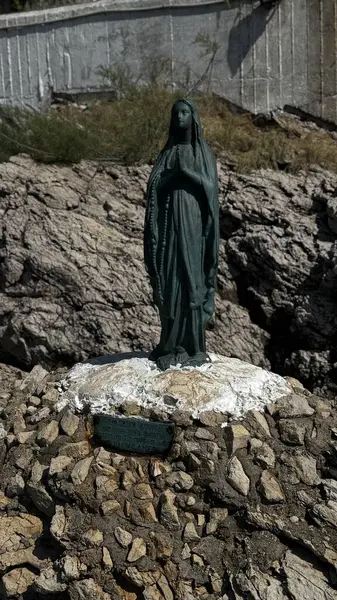Yunanistan 'ın Thassos kentindeki engebeli kıyı kayaları arasında duran beyaz taştan bir tabanda duran Bakire Meryem' in dini heykeli. Yüksek kalite fotoğraf