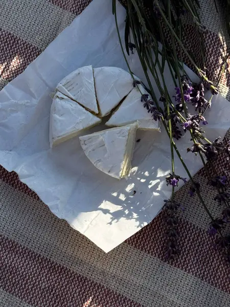 Çizgili piknik battaniyesinde lavantalı peynir dilimleri.