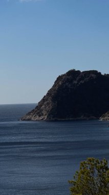 Ibiza açıklarındaki ıssız kayalık ada sakin mavi sularla çevrili..