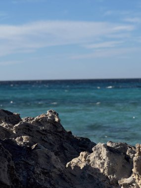 İspanya, Balear Adaları, İbiza 'daki turkuaz Akdeniz suları ile manzaralı kayalık kıyı şeridi.