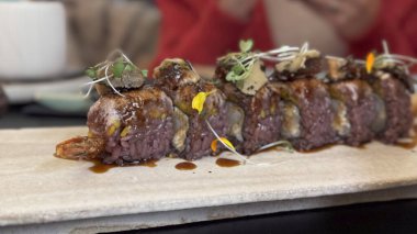 Valencia restoranındaki ahşap bir tahtada servis edilen sulu ızgara et şişleri otlar ve sosla süslenmiş..