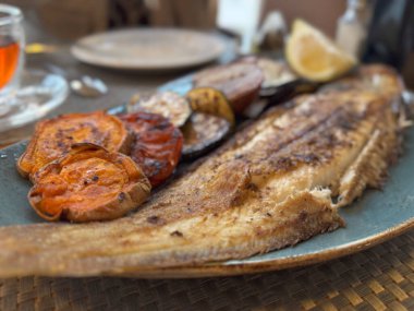 Gurme Akdeniz deniz ürünleri tabağı taze sebzelerle servis edilir, İbiza 'da güzel bir restoranda ızgarada mükemmelce pişirilir..