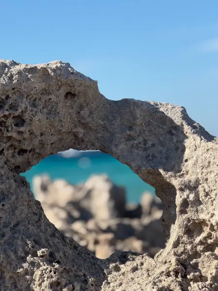 Formentera adasındaki Turkuaz Akdeniz sularını çerçeveleyen doğal kaya penceresi, Balear Adaları.