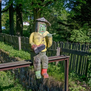 Kova, antik ahşap bir köprünün arka planında eski ahşap bir heykel.