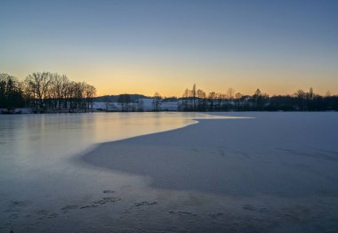 Kışın gün batımında donmuş göl