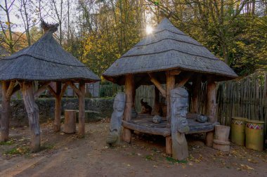 Bir Afrika köyünün kopyasında sonbahar öğleden sonra, sazlık çatılar, ağaçlardaki sarı yapraklar