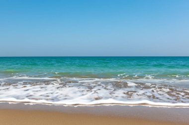 Mavi gökyüzünün altında büyüleyici bir okyanus sahili