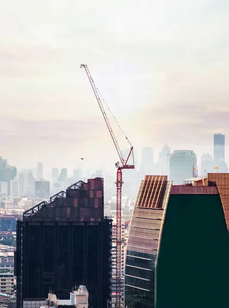 Gün batımında şehrin inşasında kullanılan inşaat alanlarındaki vinç hakkında.